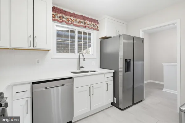 a kitchen with stainless steel appliances granite countertop a refrigerator and a sink