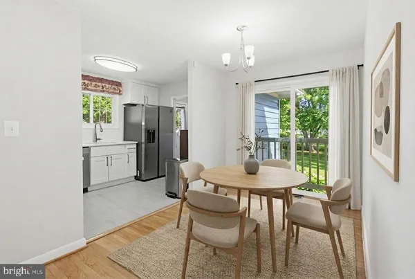 a kitchen with stainless steel appliances a table chairs and a refrigerator