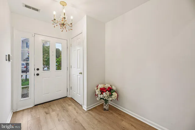 a hallway with a wooden floor and a chandelier