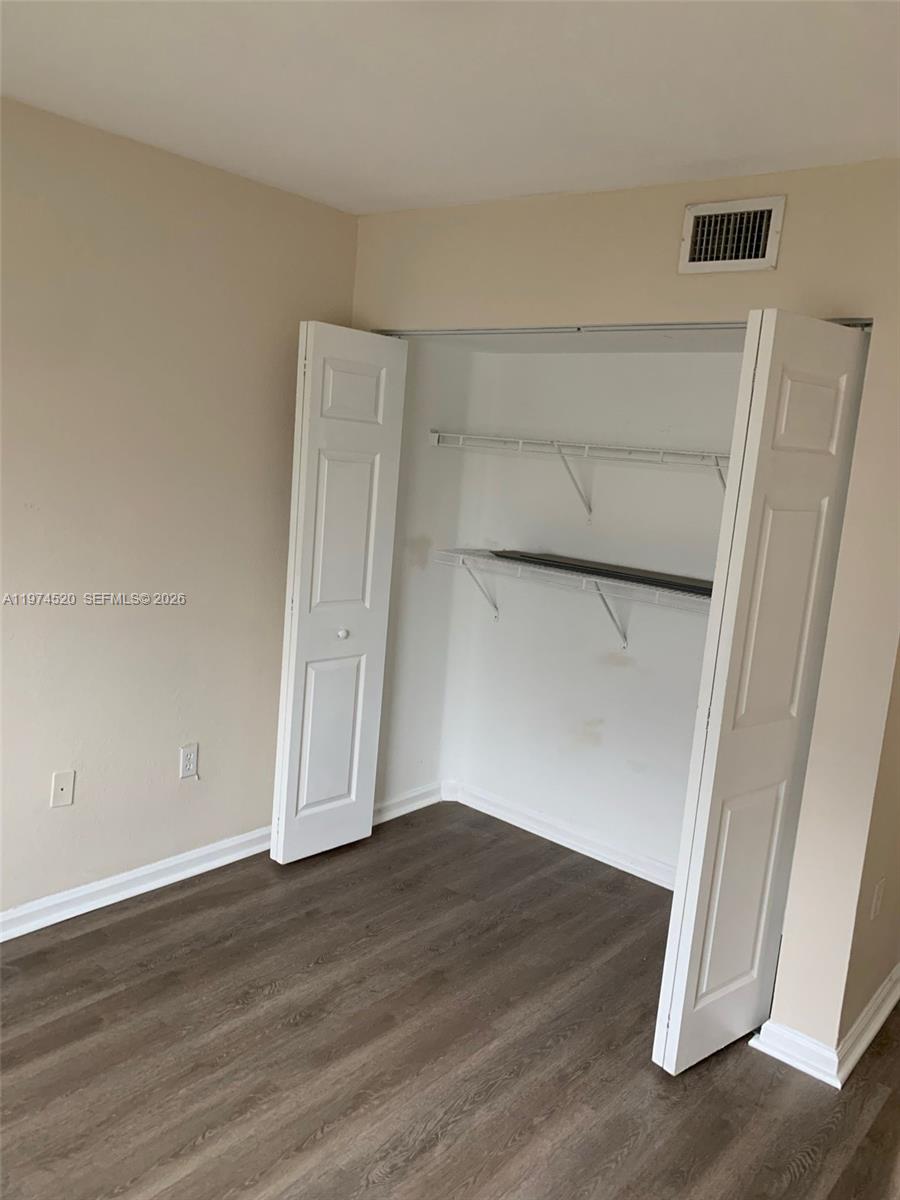15440 Southwest 284th Street, Unit 5102 Homestead, FL 33033 - Photo 12 of 27 an empty room with wooden floor and cabinet