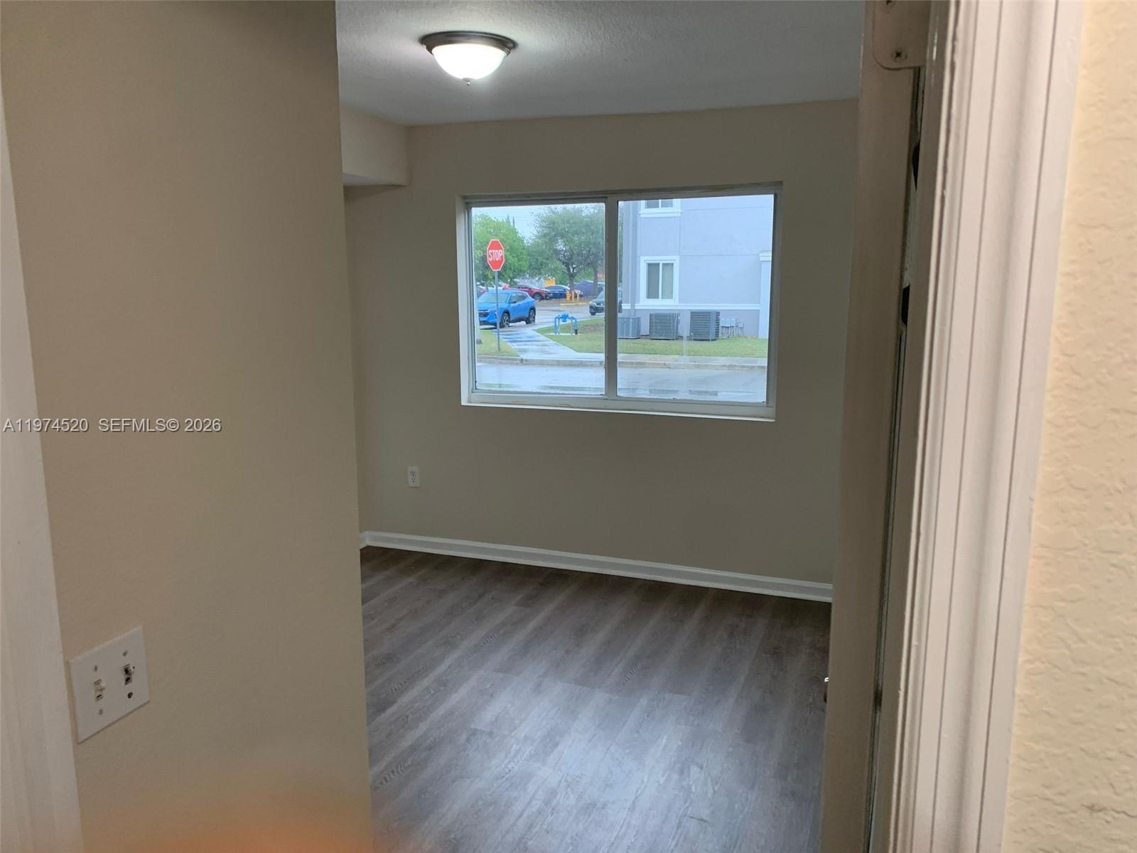 15440 Southwest 284th Street, Unit 5102 Homestead, FL 33033 - Photo 23 of 27 an empty room with wooden floor and windows