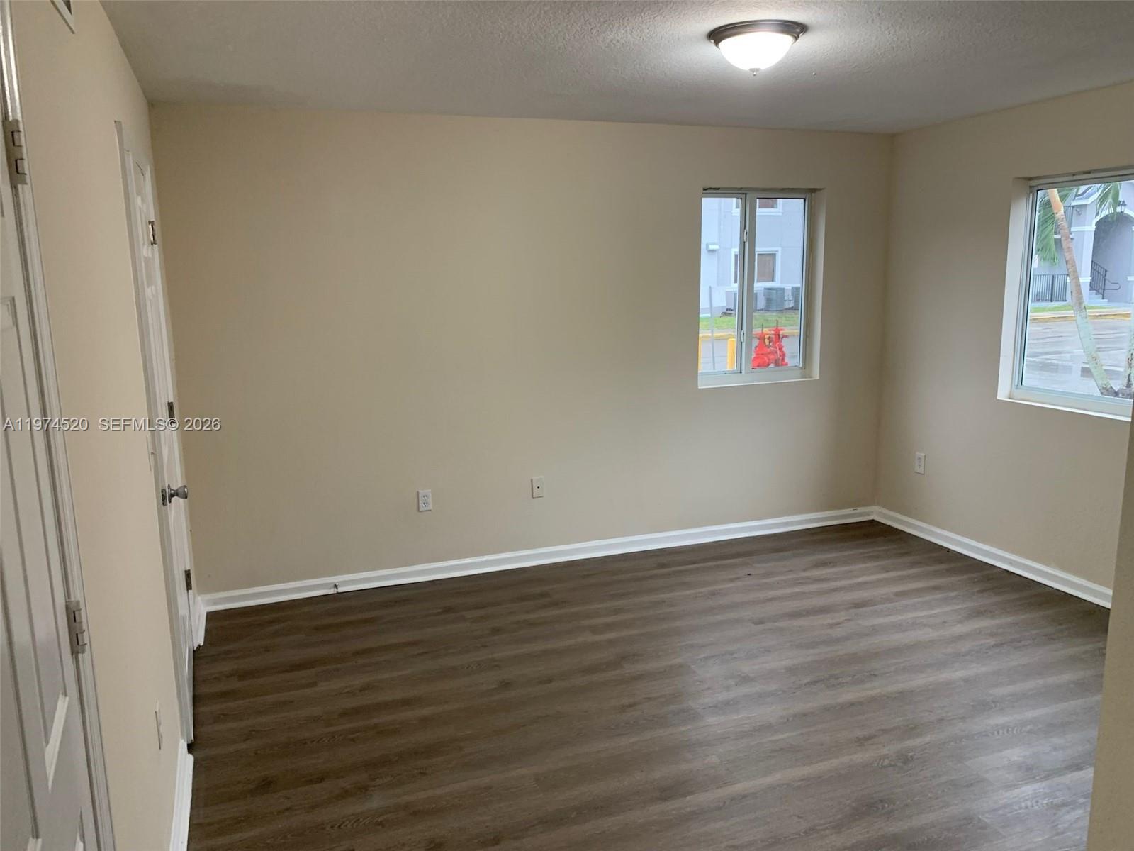 15440 Southwest 284th Street, Unit 5102 Homestead, FL 33033 - Photo 7 of 27 a view of an empty room with wooden floor and a window