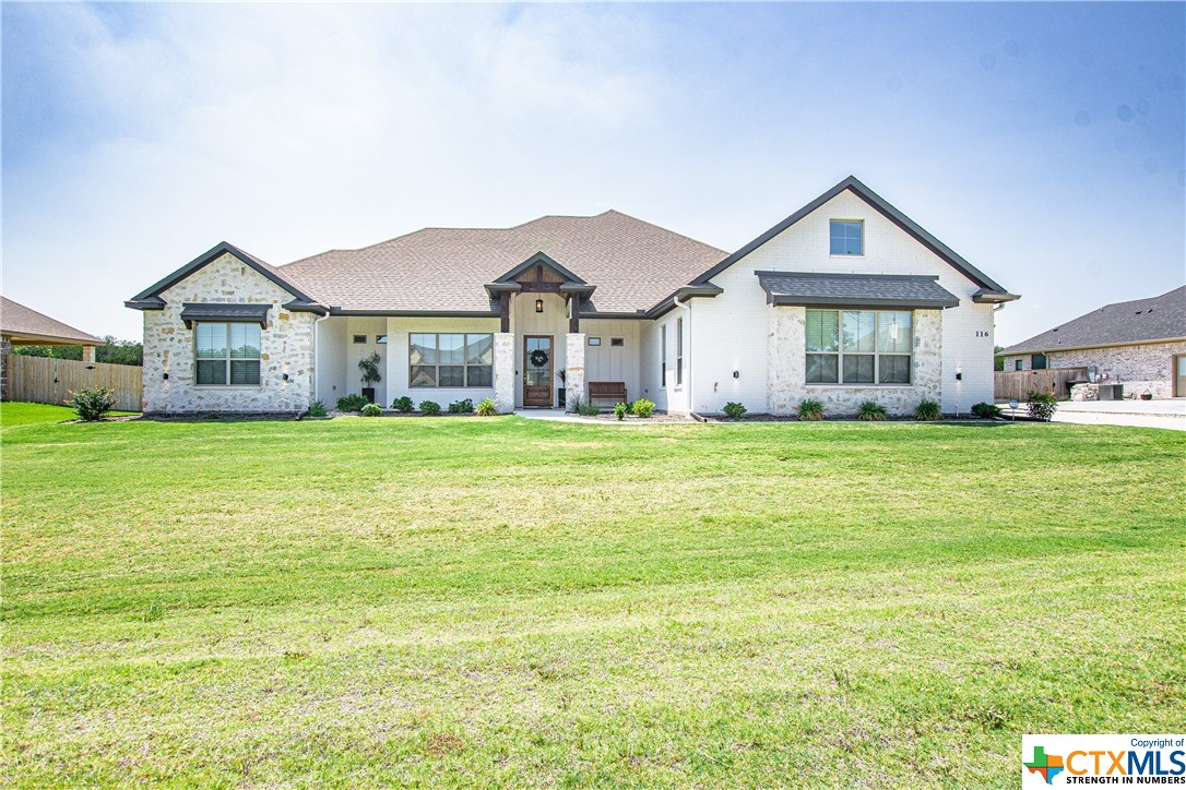 a view of a house with a big yard and large trees