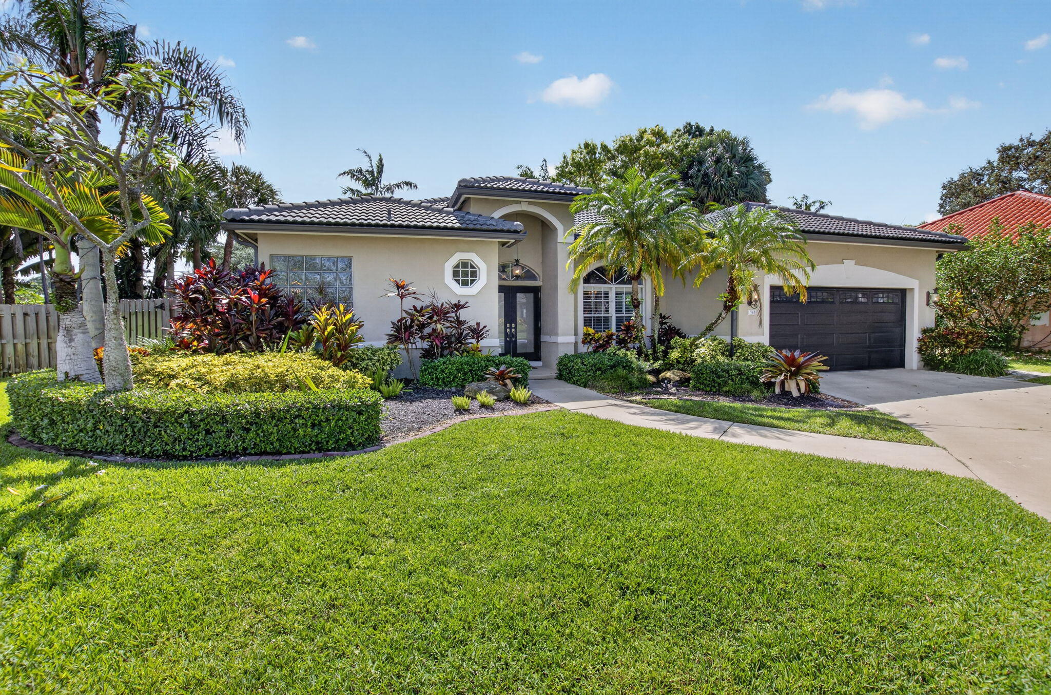 1365 East Barwick Ranch Circle Delray Beach, FL 33445 - Photo 2 of 77 a front view of a house with a yard and potted plants