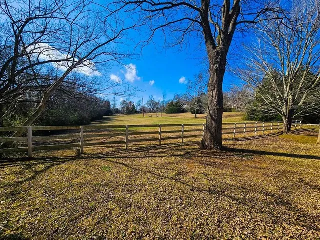 a view of a yard with wooden fence