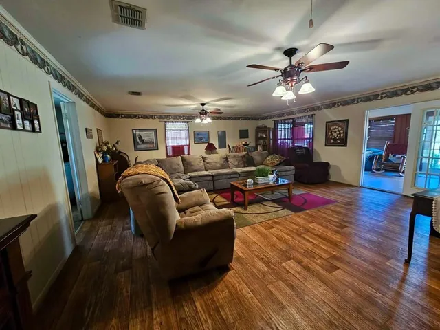 a living room with furniture and a wooden floor