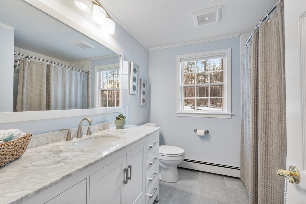 420 Old Harvard Road Boxborough, MA 01719 - Photo 30 of 37 a bathroom with a granite countertop sink a toilet and a window