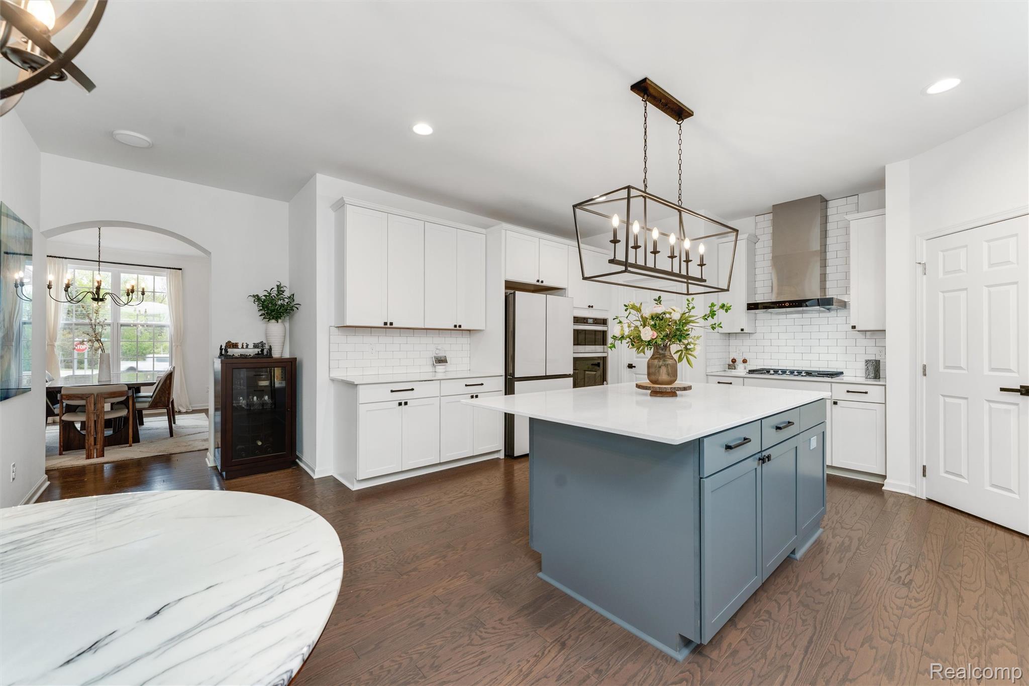 908 South Livernois Road Rochester, MI 48309 - Photo 7 of 49 Kitchen featuring suspended lighting, two tone cabinetry, a center island, freestanding refrigerator, and dark wood-style flooring