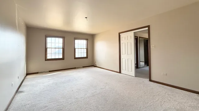 an empty room with windows and door