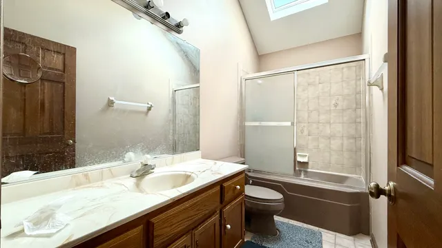 a bathroom with a granite countertop sink toilet and shower