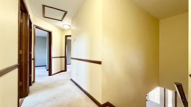 a view of a hallway with a white cabinet and a refrigerator