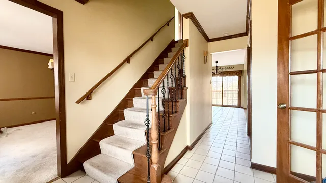 a view of staircase with lots of frames on wall and a large window