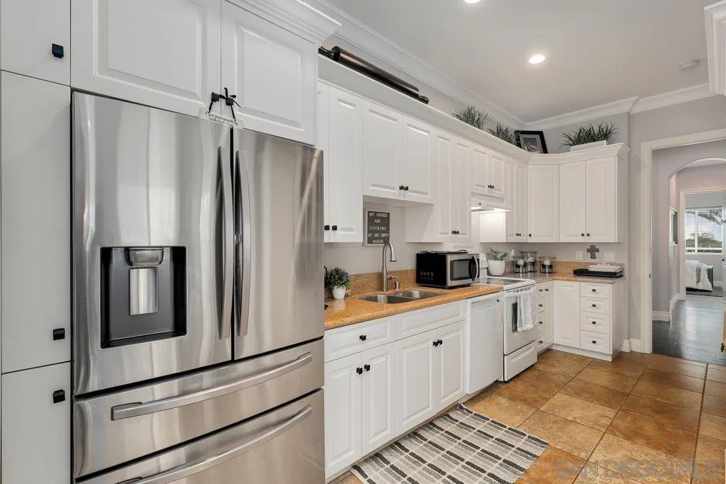 11130 Boulder Pass Escondido, CA 92026 - Photo 31 of 55 a kitchen with white cabinets and white appliances