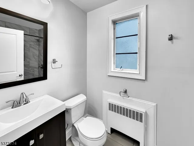 a bathroom with a sink vanity mirror and toilet