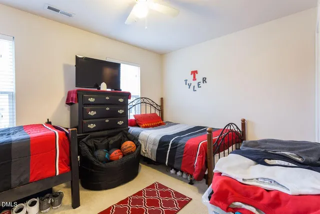 a bedroom with two bed and a flat tv screen on dresser