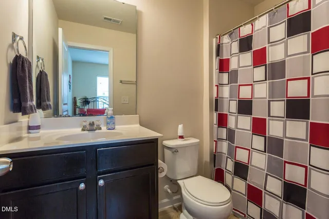 a bathroom with a sink a toilet a mirror and shower