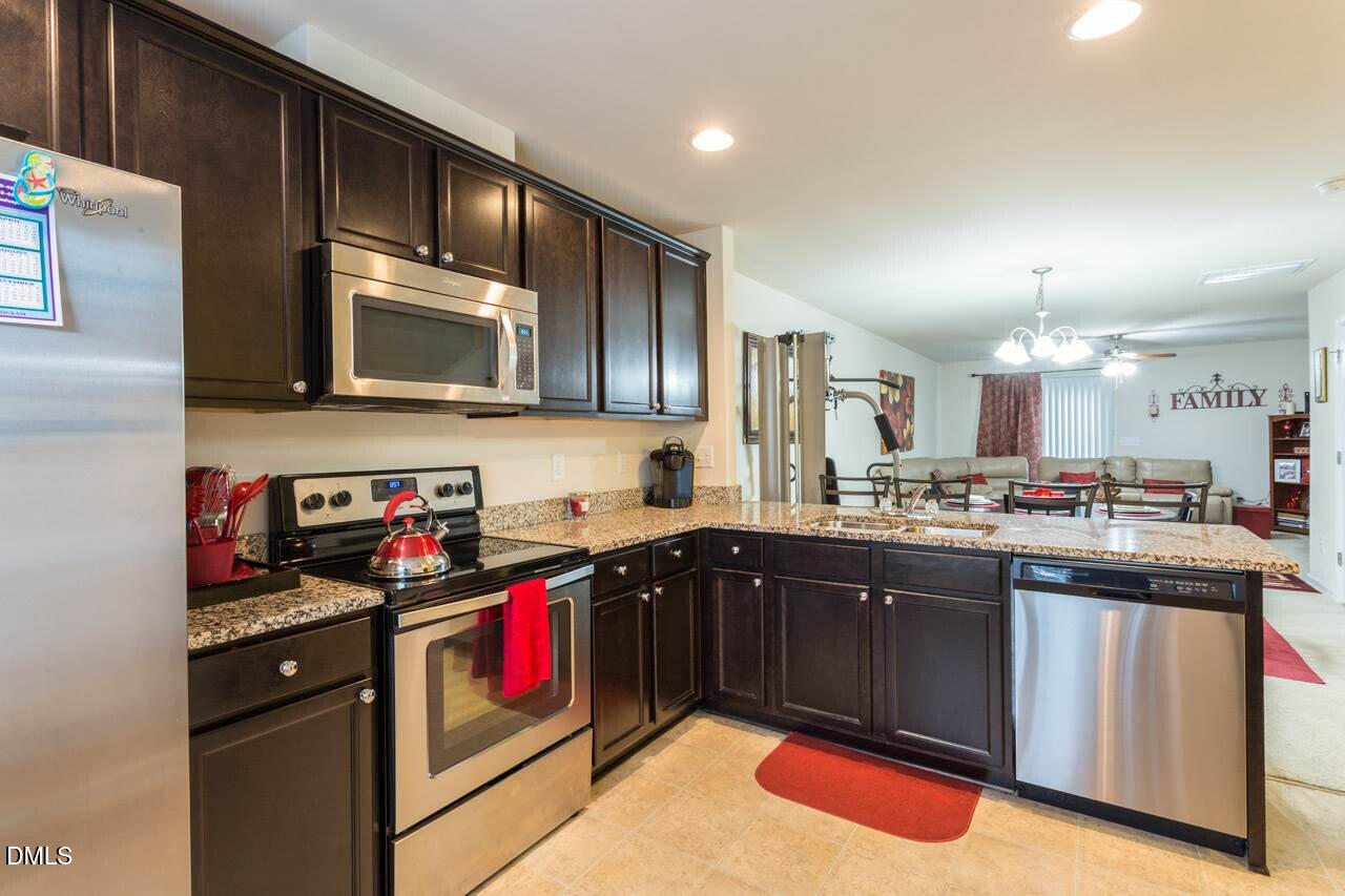 4009 Tresco Crossing Raleigh, NC 27616 - Photo 10 of 23 a kitchen with stainless steel appliances granite countertop a stove a sink dishwasher and a microwave oven with cabinets