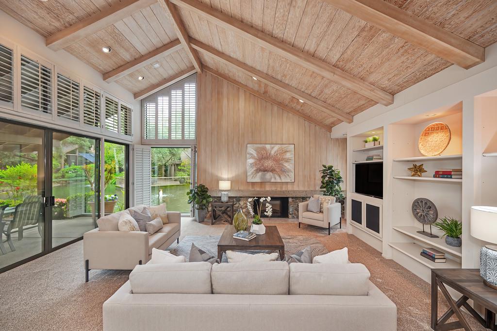 7650 Pineridge Road Fair Oaks, CA 95628 - Photo 11 of 67 Large, open living room with a fireplace, open-beam ceiling, built-in cabinets, and views of the lake