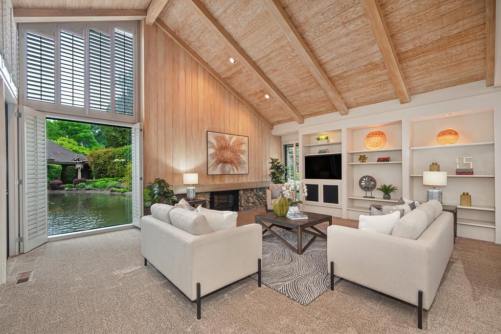 7650 Pineridge Road Fair Oaks, CA 95628 - Photo 12 of 67 Large, open living room with a fireplace, open-beam ceiling, built-in cabinets, and views of the lake