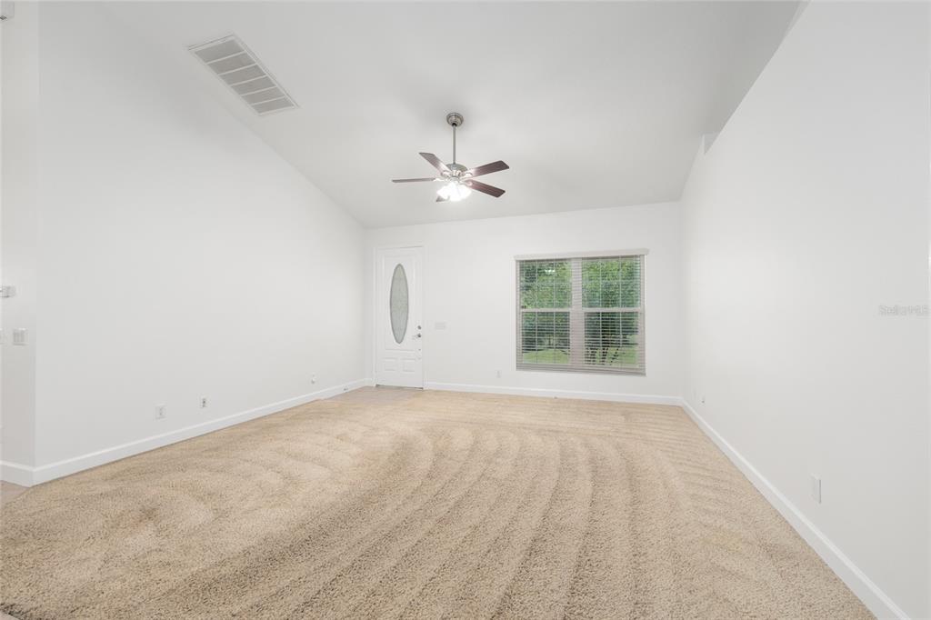 4735 Southeast 112th Street Road Belleview, FL 34420 - Photo 18 of 73 an empty room with windows and ceiling fan