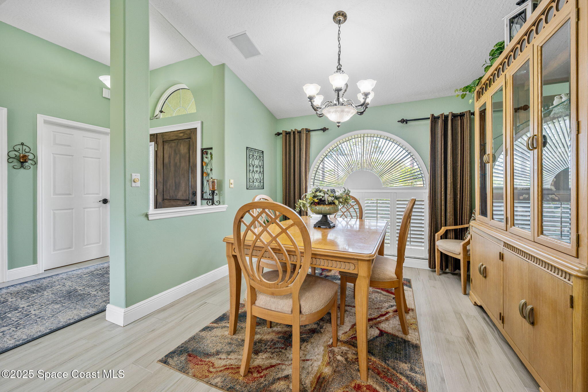 4385 Windover Way Melbourne, FL 32934 - Photo 15 of 44 a view of a dining room with furniture a chandelier and wooden floor