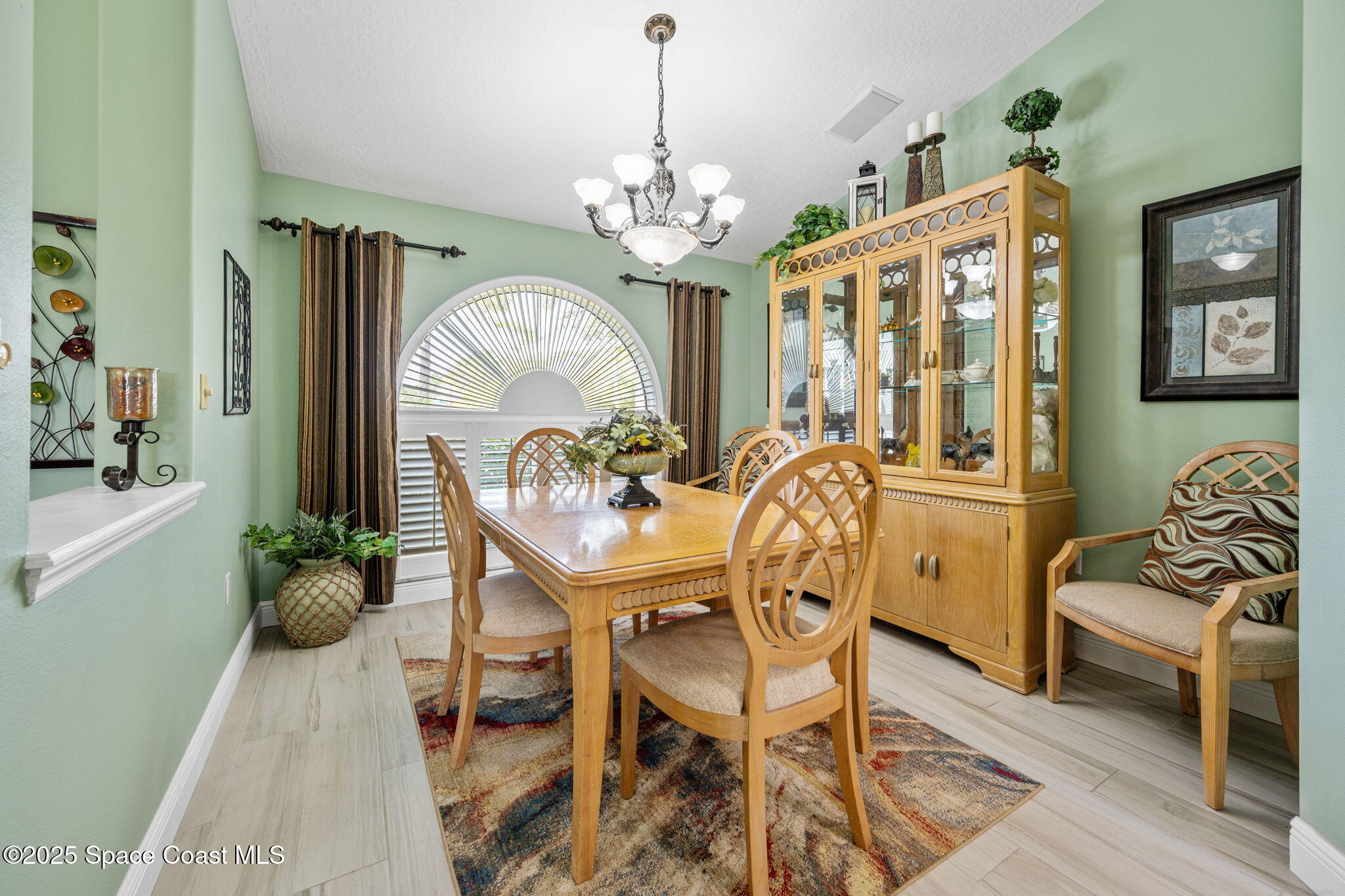 4385 Windover Way Melbourne, FL 32934 - Photo 16 of 44 a view of a dining room with furniture a chandelier and wooden floor