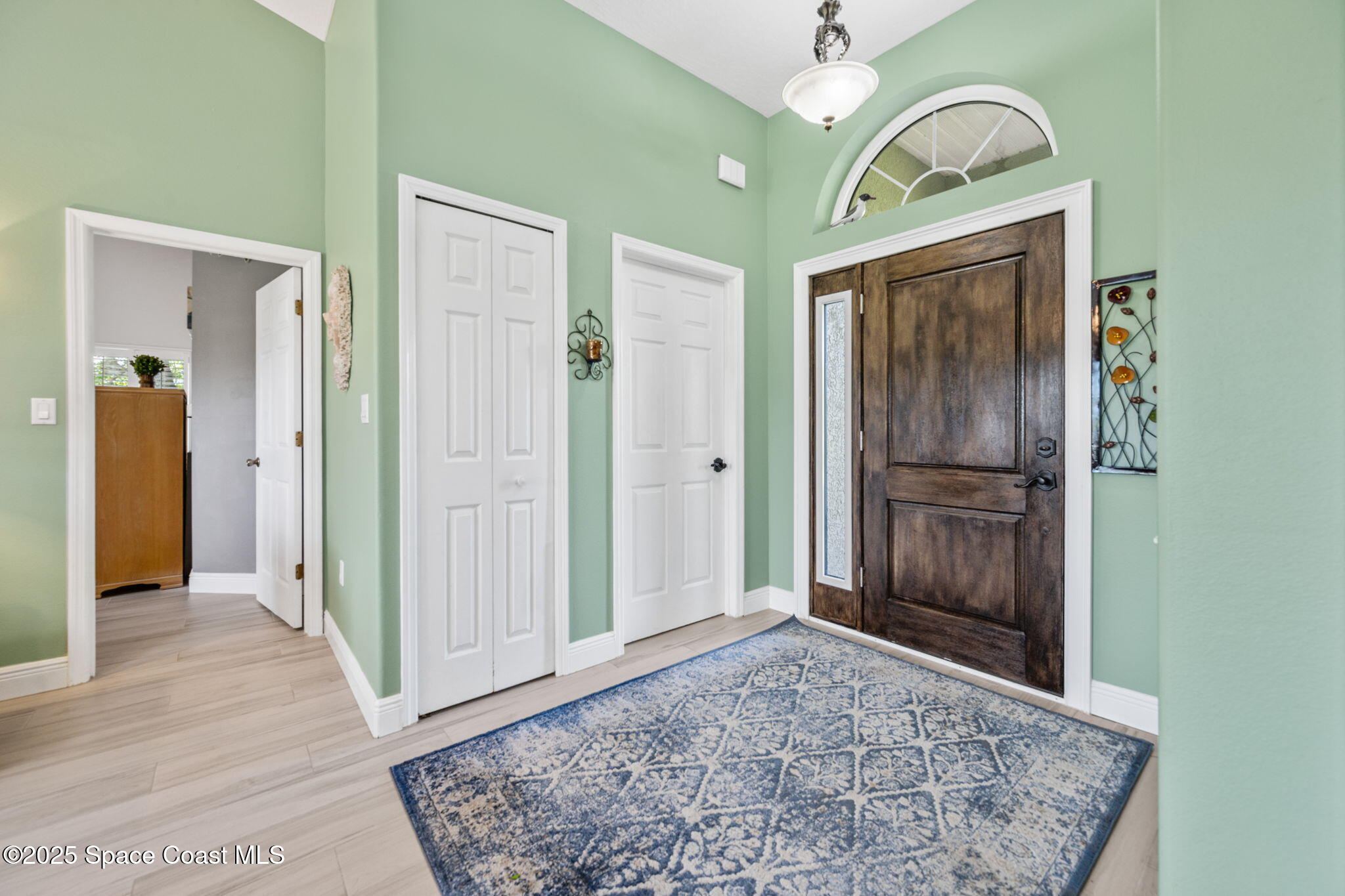 4385 Windover Way Melbourne, FL 32934 - Photo 10 of 44 a view of a hallway with entryway wooden floor and front door