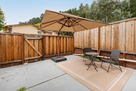 a view of backyard with a table and chairs under an umbrella