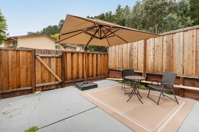 a view of backyard with a table and chairs under an umbrella