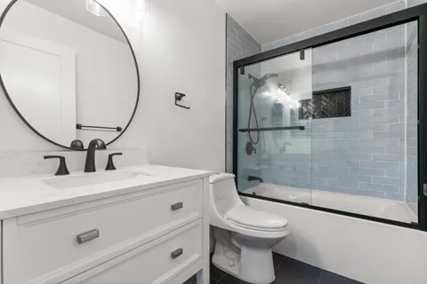a bathroom with a sink a toilet and a mirror