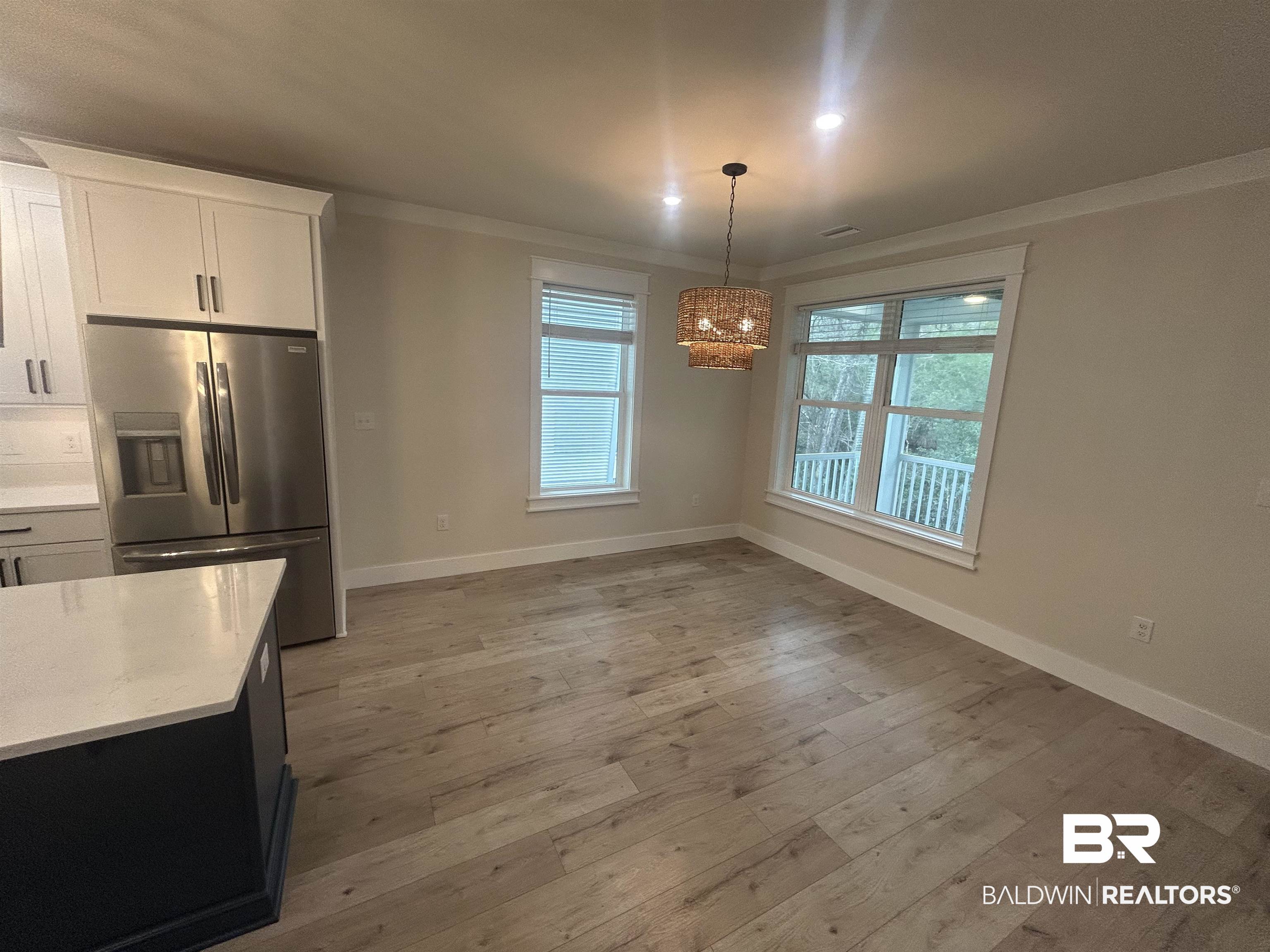5122 Pine Road Orange Beach, AL 36561 - Photo 6 of 24 Unfurnished dining area featuring light wood-style flooring, crown molding, and a chandelier