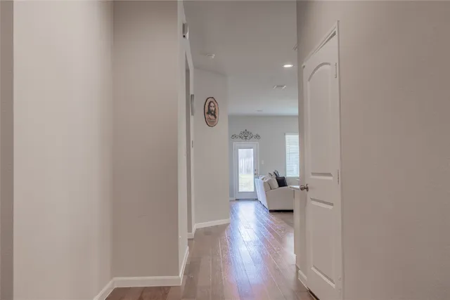 a view of a hallway with wooden floor and a living room