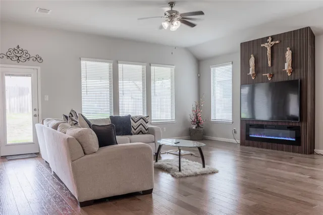 a living room with furniture and a wooden floor
