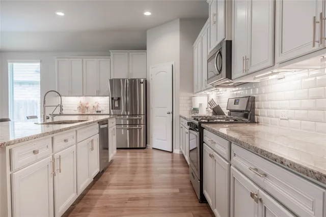 a kitchen with stainless steel appliances granite countertop a refrigerator sink and cabinets