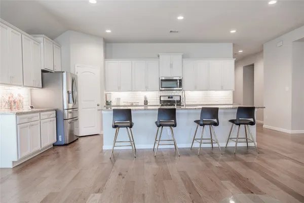 a kitchen with kitchen island wooden cabinets and stainless steel appliances