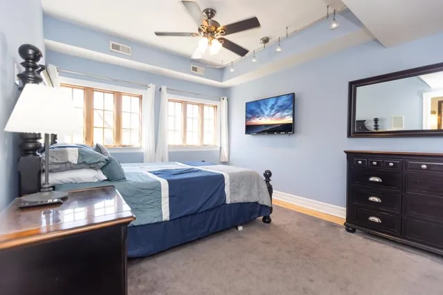 a spacious bedroom with a bed and a dresser