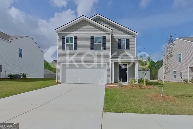 a front view of a house with a garden and yard