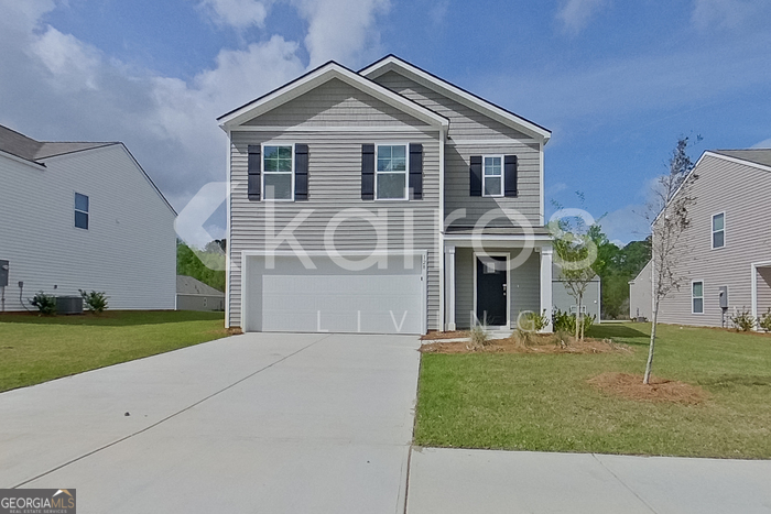 a front view of a house with a garden and yard