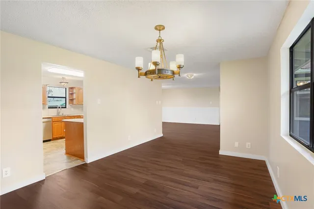 a view of empty room with wooden floor and window