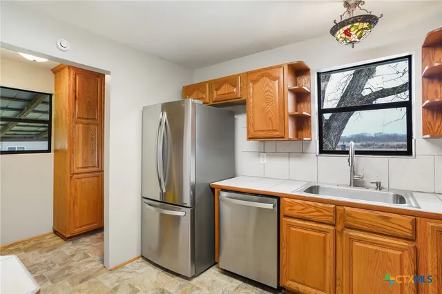 a kitchen with stainless steel appliances a refrigerator and a sink