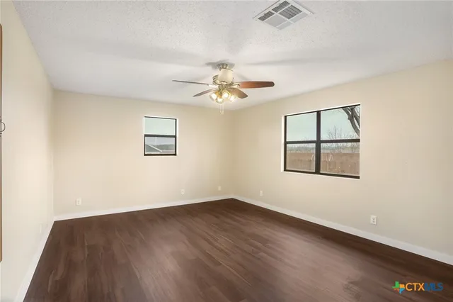 a view of a big room with wooden floor and windows