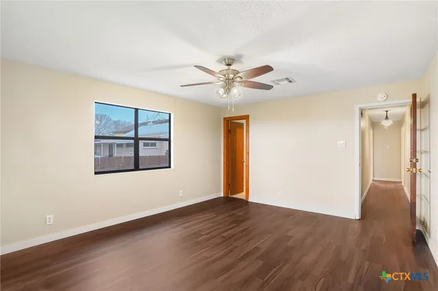 a view of an empty room with wooden floor