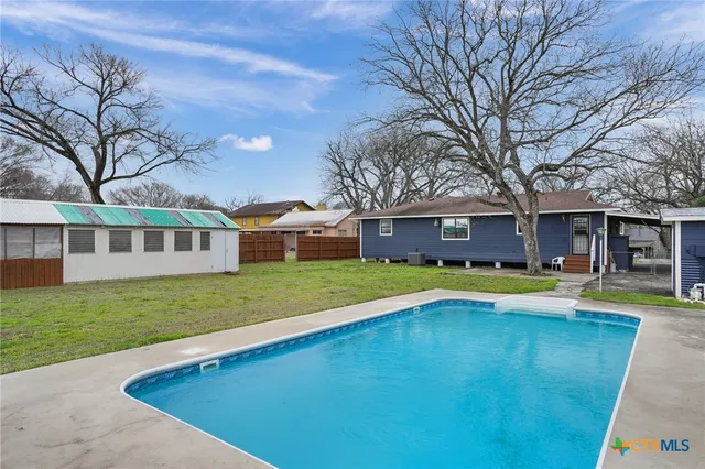 a view of an house with swimming pool and yard