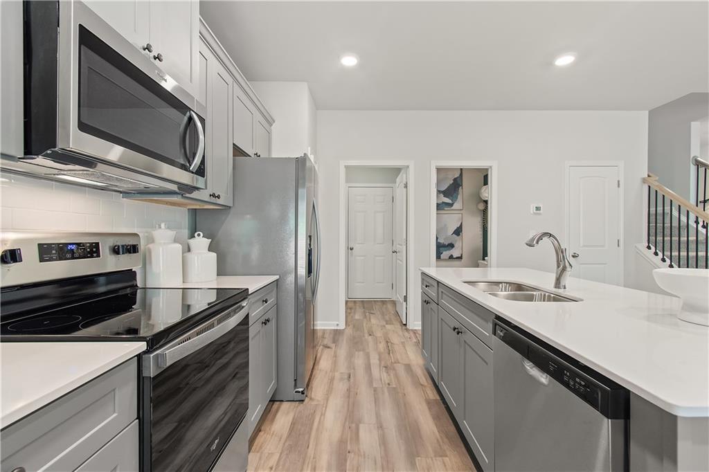 631 Treasure Drive Stockbridge, GA 30281 - Photo 14 of 33 a kitchen with stainless steel appliances granite countertop a sink stove and refrigerator