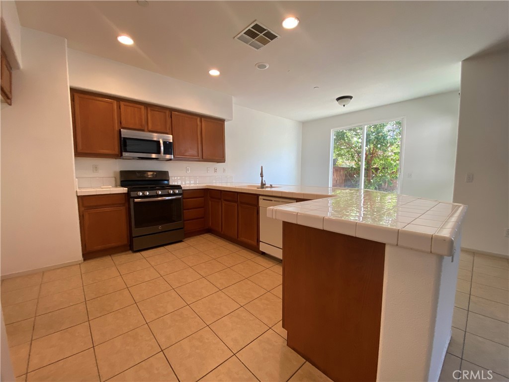 a kitchen with stainless steel appliances granite countertop a stove sink and cabinets