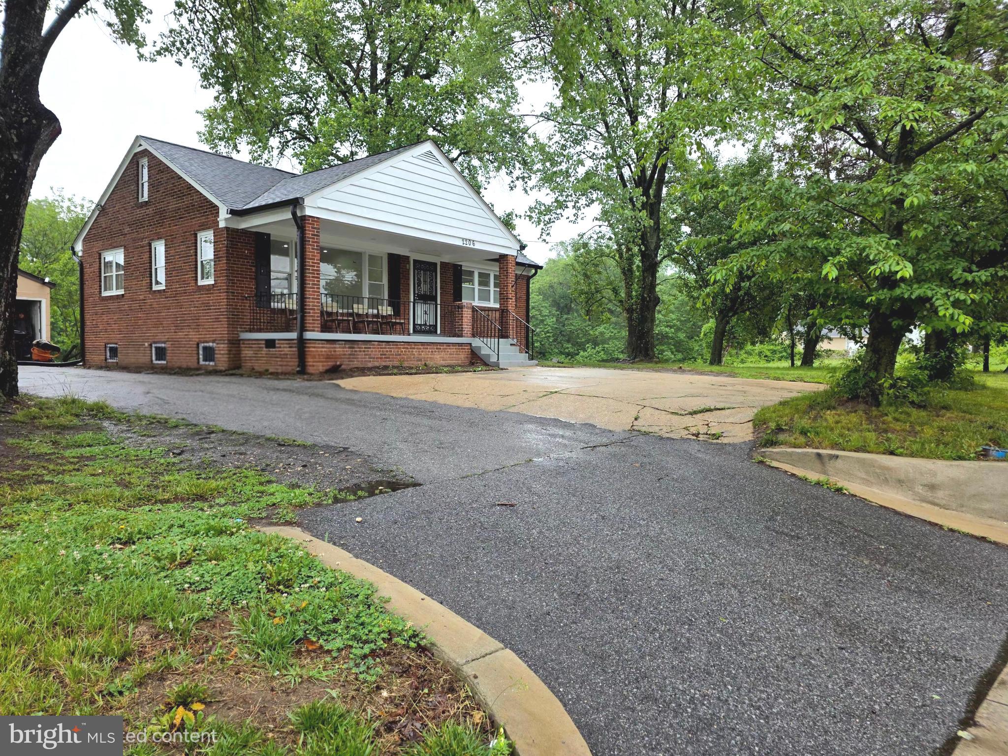 2206 Brinkley Road Fort Washington, MD 20744 - Photo 4 of 78 a front view of a house with a garden and trees