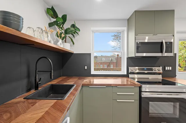 a kitchen with a stove a microwave and cabinets