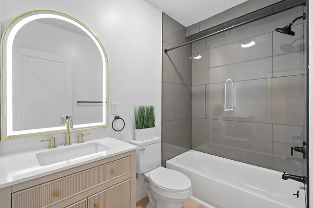 a bathroom with a sink a toilet and shower