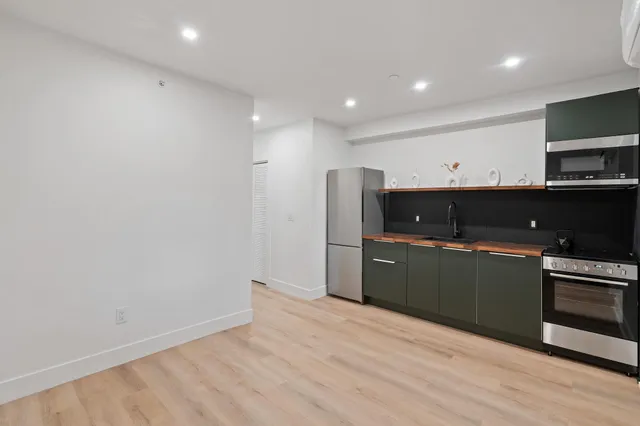 a kitchen with stainless steel appliances a refrigerator and a microwave