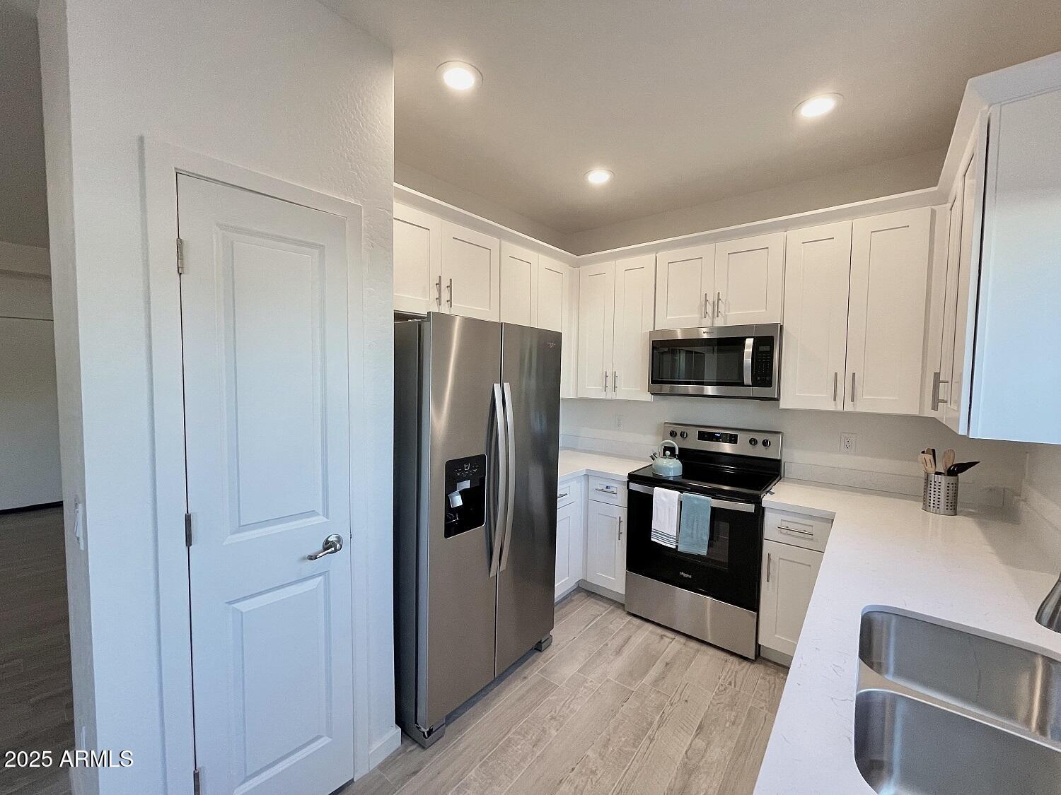 701 North McQueen Road, Unit 12 Chandler, AZ 85225 - Photo 2 of 15 a kitchen with stainless steel appliances a refrigerator a stove top oven a sink and dishwasher